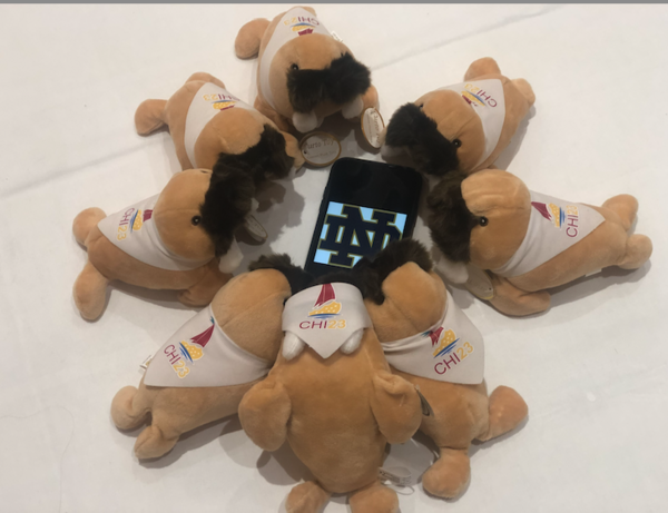 Promotional walruses arranged around a phone with the interlocking ND symbol on the screen at CHI 2023